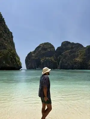 Edmond sur une plage à l'eau turquoise